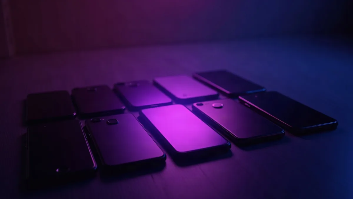 Meerdere smartphones op een rij, een paarse spot op de middelste (illustratie bij het artikel)